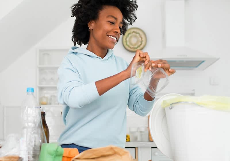 Frau, die ihren Müll wegschmeißt