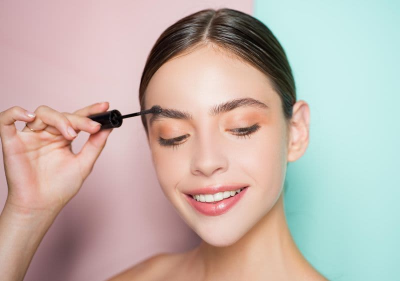 Junge Frau beim Augenbrauen stylen
