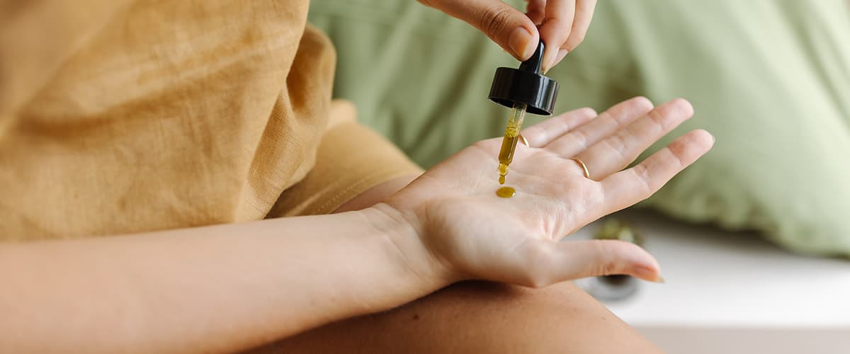 Jojobaoel auf Handflaeche tropfen