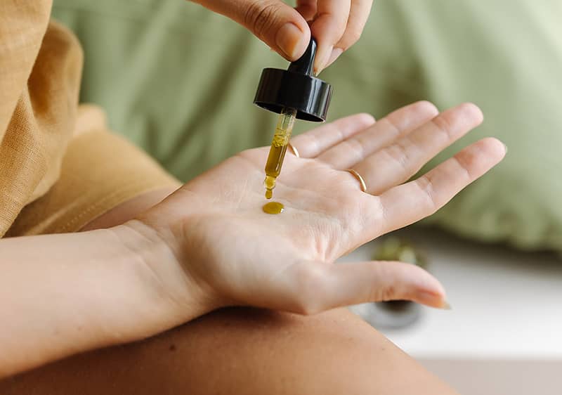 Jojobaoel auf Handflaeche tropfen