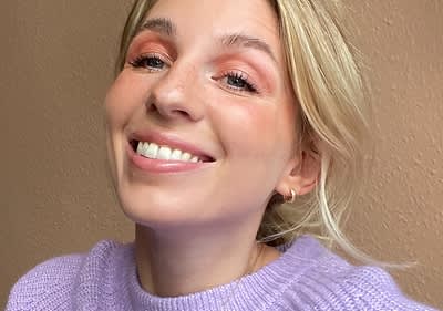 Blonde Frau mit Augen-Make-up laechelnd