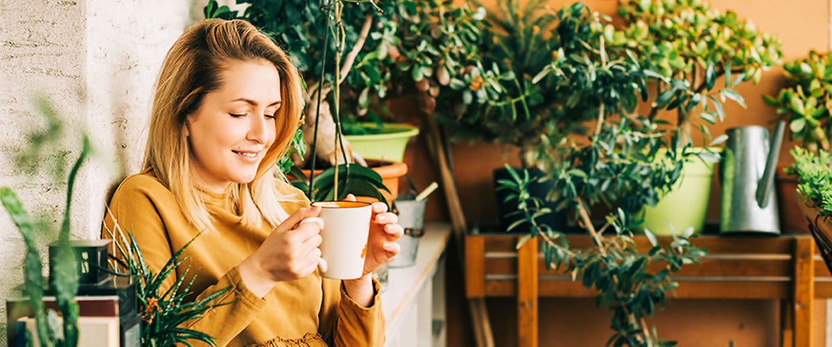 Frau mit Teetasse auf Balkon