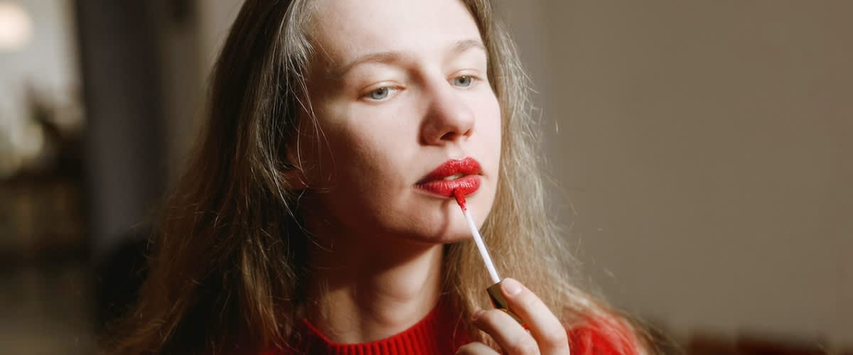 Frau schminkt rote volle Lippen
