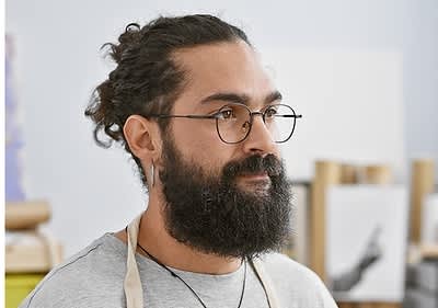 Mann mit Bart und Brille in einem Atelier