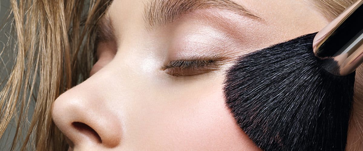 Frau mit Puderpinsel