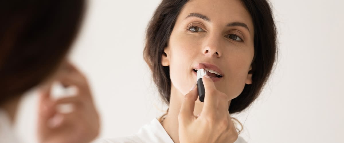 Frau trägt Lippenstift auf