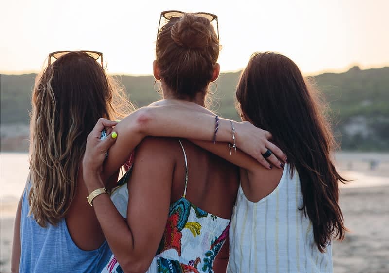 Drei Frauen bei Sonnenuntergang am Meer
