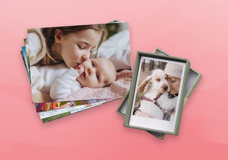 Ein Stapel Fotos zeigt ein Baby in rosa Kleidung und einen Hund mit einem verschwommenen Gesicht daneben in einer Box