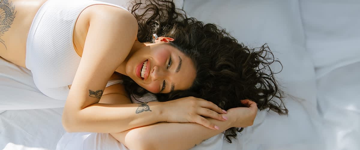 Eine lachende Frau im Bett