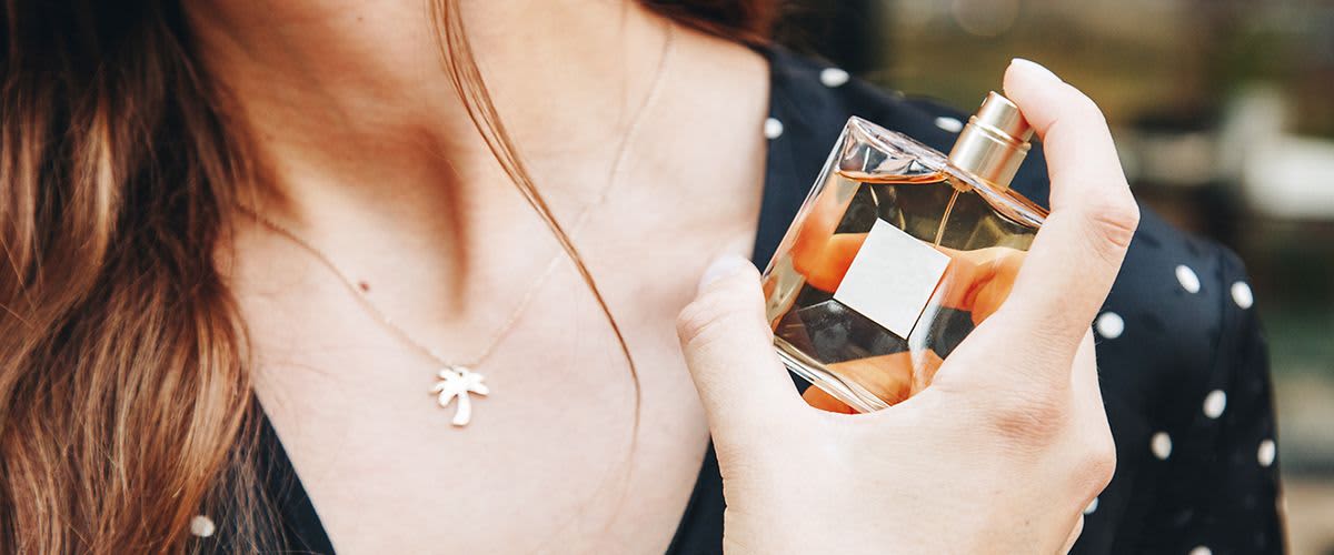 Frau sprüht Duft auf Handgelenk