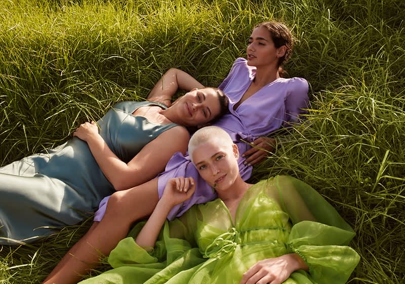 Drei Frauen liegen im Gras