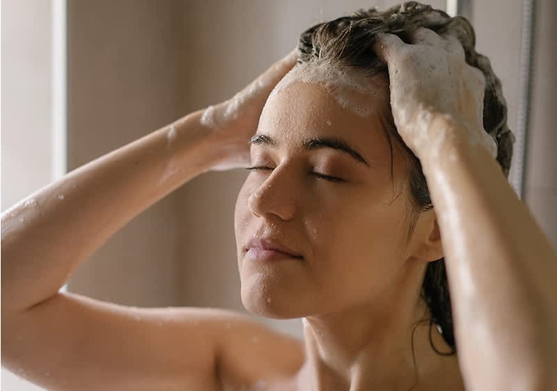 Frau beim Haare waschen