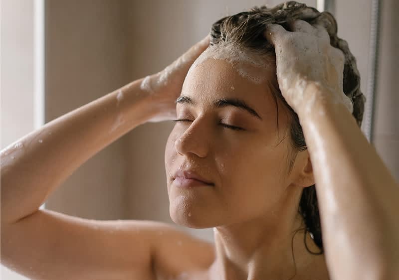Frau beim Haare waschen