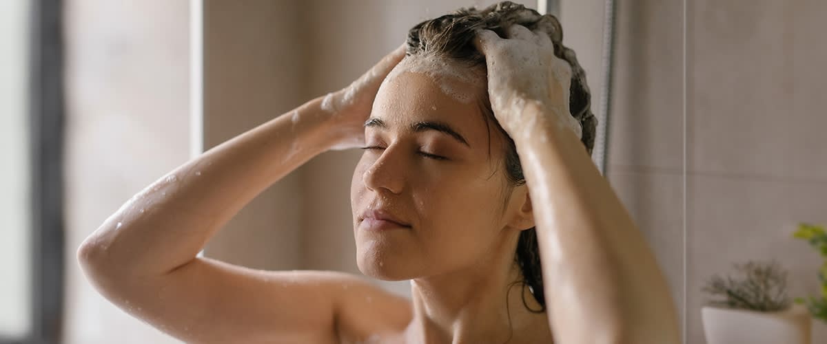 Frau beim Haare waschen