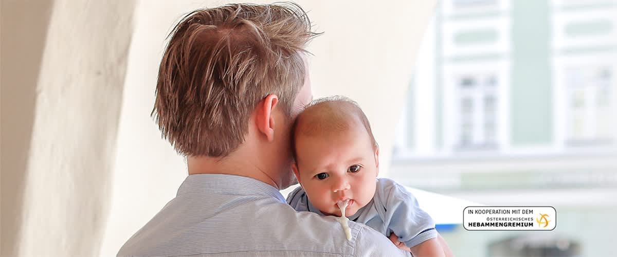 Vater traegt Baby