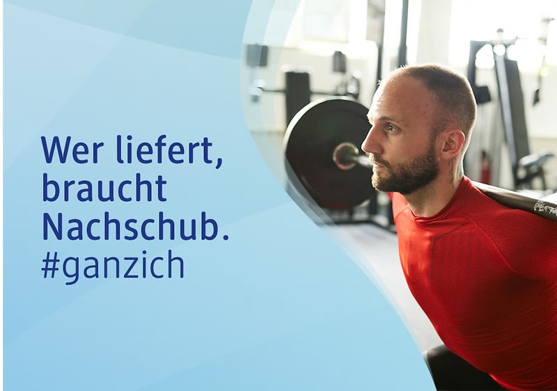 Ein Mann in rotem Sportshirt hebt eine Langhantel. Links steht der Text: „Wer liefert, braucht Nachschub. #ganzich“