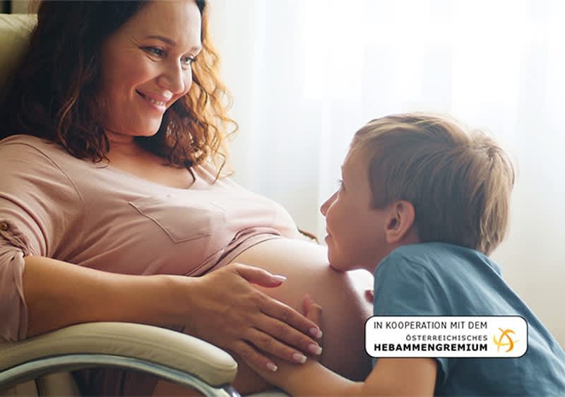 Schwangere Frau mit kleinem Kind bei ihrem Bauch