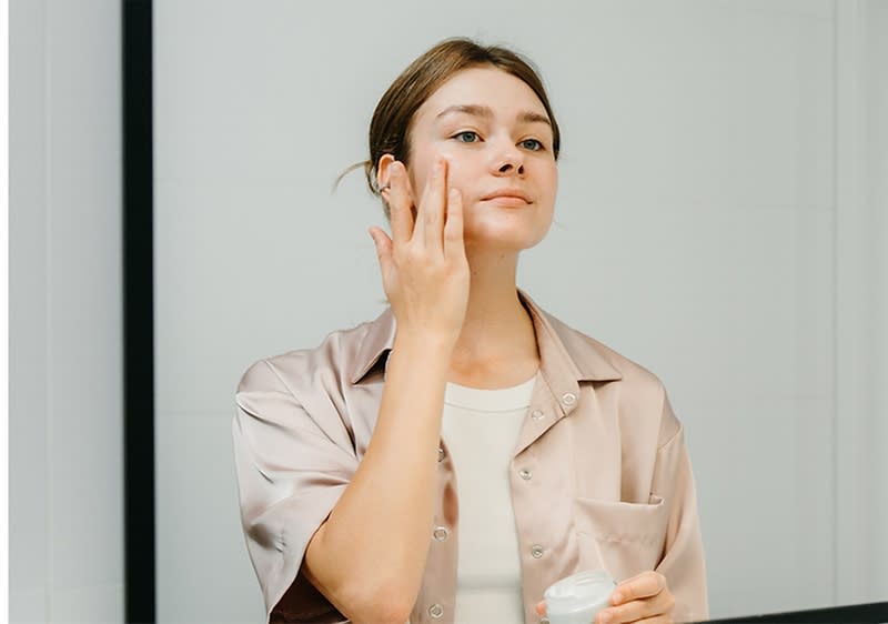 Junge Frau mit Haarturban bei der Gesichtspflege