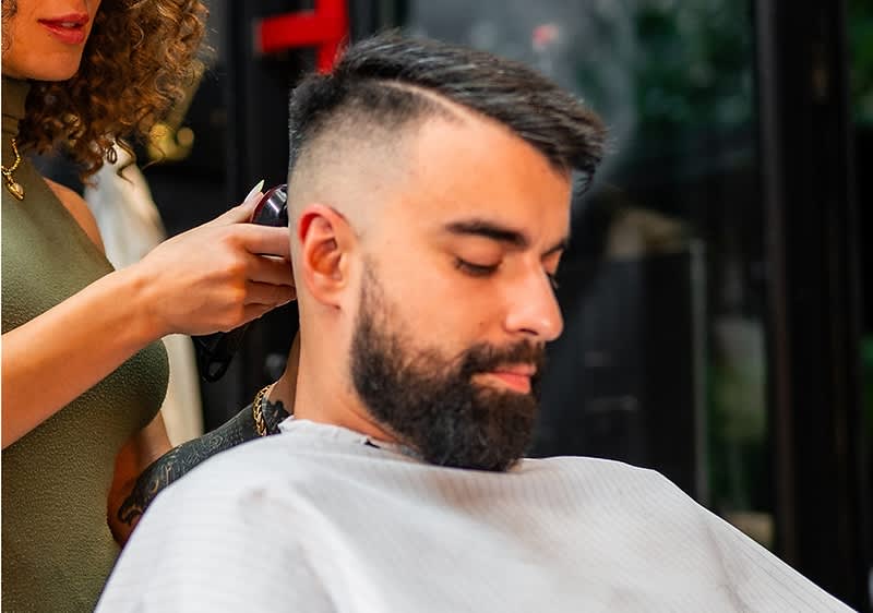 Friseur schneidet Haare eines Mannes im Salon zu einem Undercut