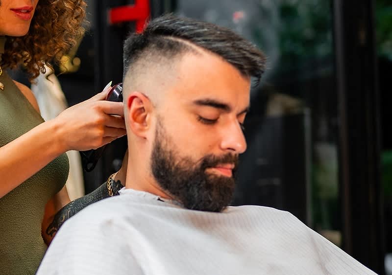 Friseur schneidet Haare eines Mannes im Salon zu einem Undercut