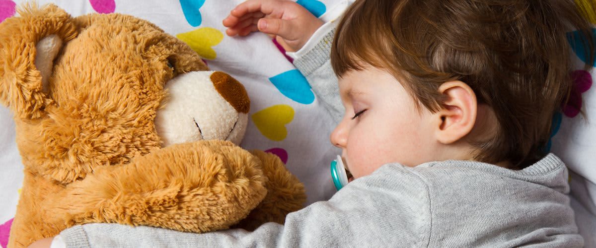 Kind schläft mit Daddybär