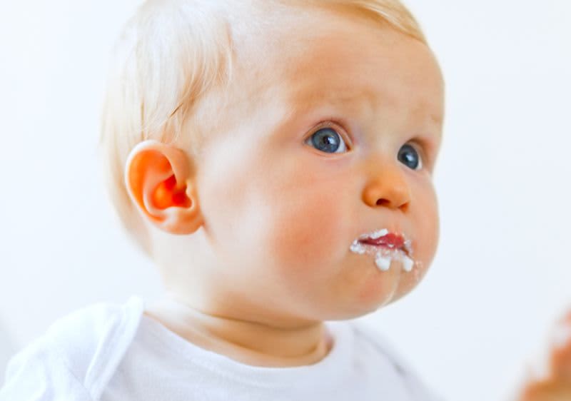 Baby mit Brei um den Mund