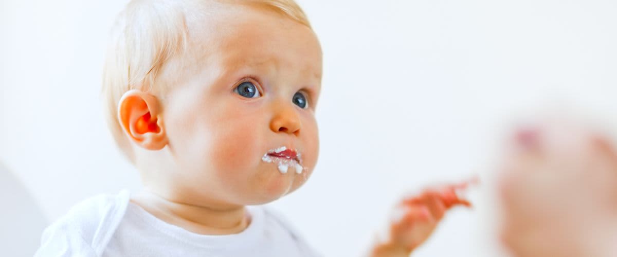 Baby mit Brei um den Mund