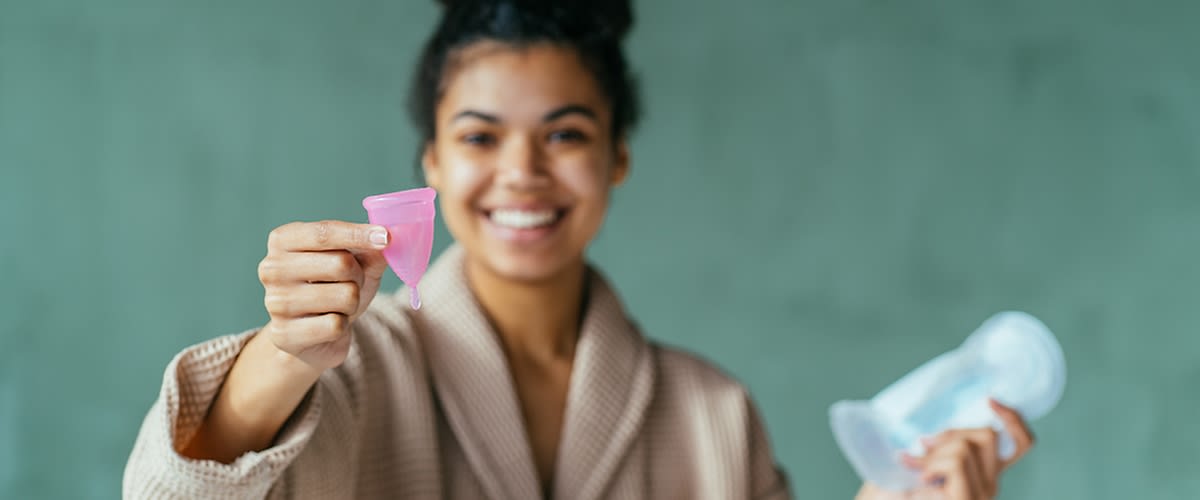 Junge Frau mit Menstruationstasse in der Hand