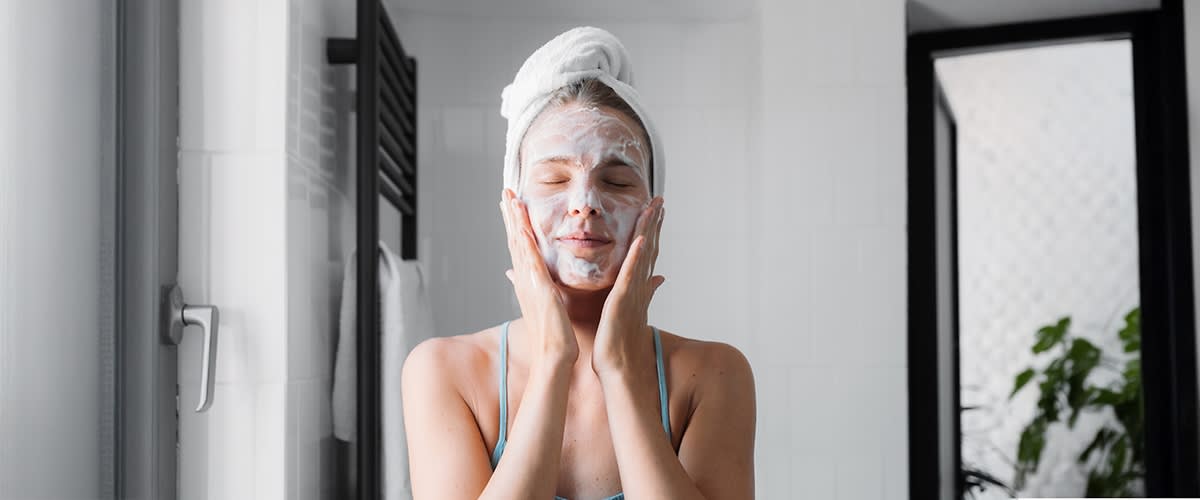 Frau im Badezimmer mit Handtuch auf dem Kopf