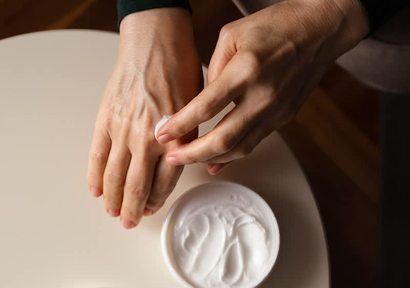 Hände mit Handcreme eincremen