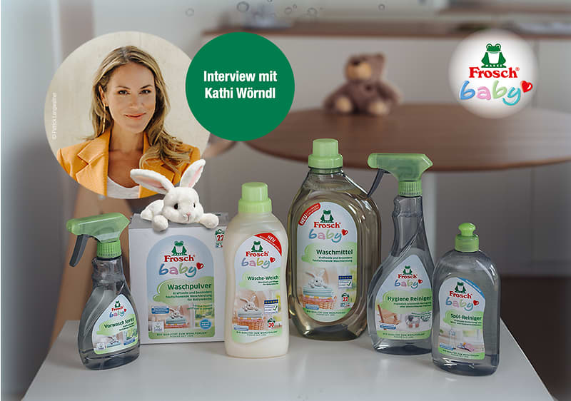 Sechs Frosch Baby-Reinigungsprodukte nebeneinander: zwei Sprayflaschen, Waschpulverkarton mit Stoffhase, zwei Flaschen Flüssigwaschmittel und ein Hygiene-Reiniger, alle mit grünem Logo und Babysymbol