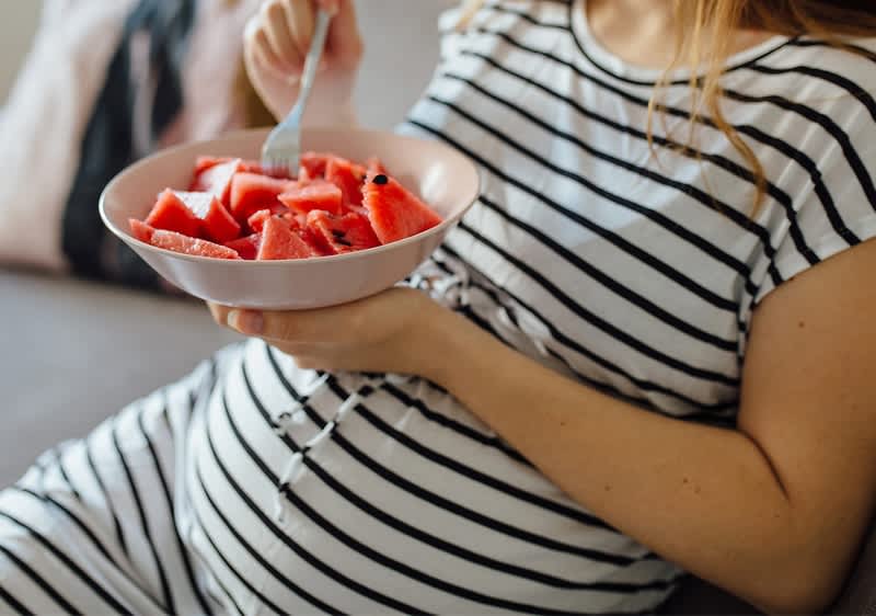 Schwangere Frau isst Obst