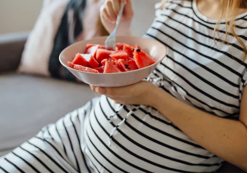 Schwangere Frau isst Obst