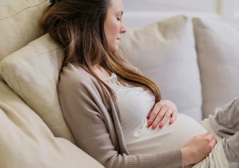 Schwangere Frau auf Sofa
