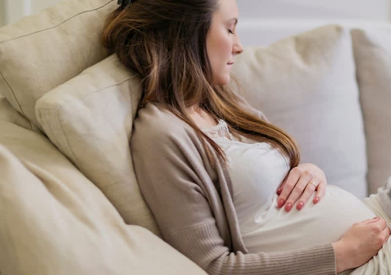 Schwangere Frau auf Sofa