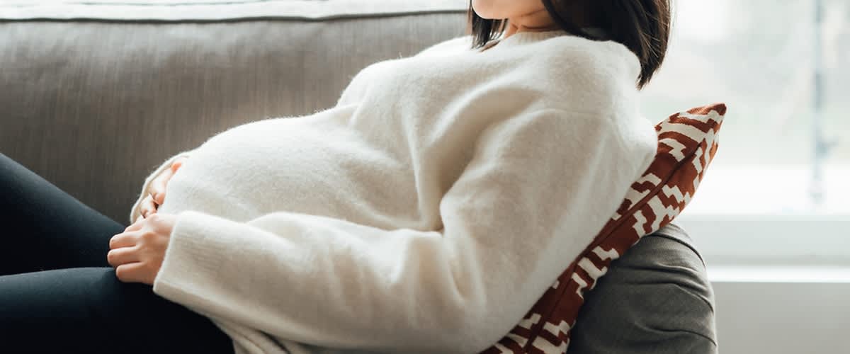 Schwangere Frau im Pullover