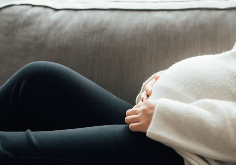 Schwangere Frau im Pullover