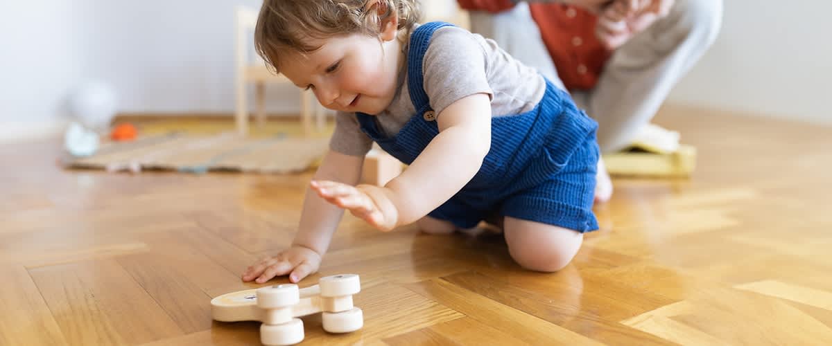 Baby beim Spielen auf einem Holzboden