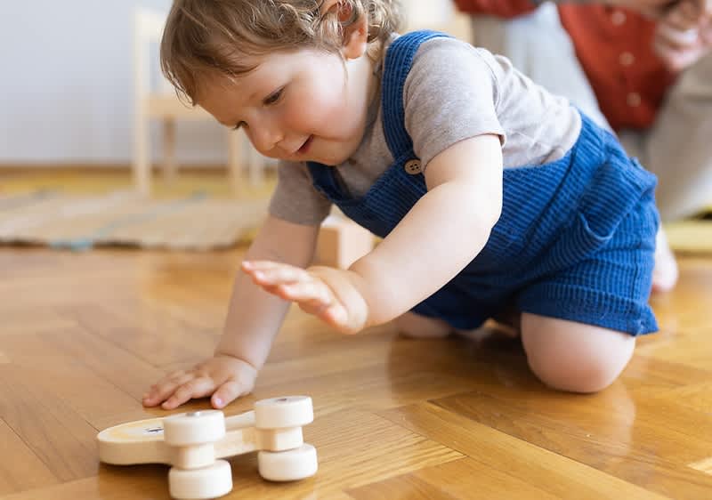 Baby beim Spielen auf einem Holzboden