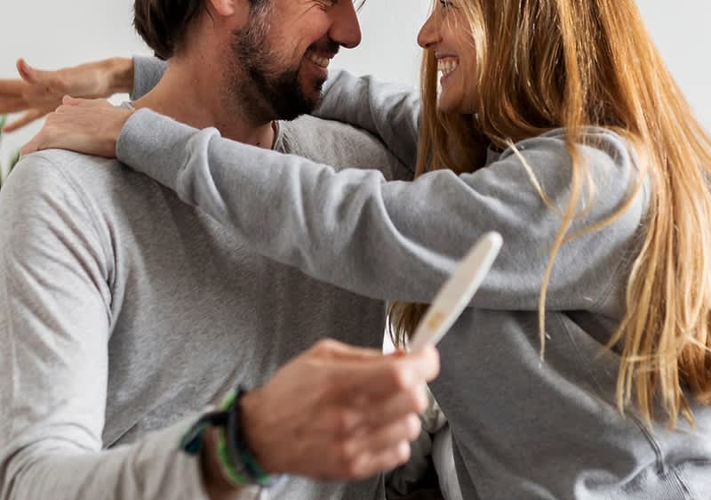 Glückliches Pärchen mit Schwangerschaftstest