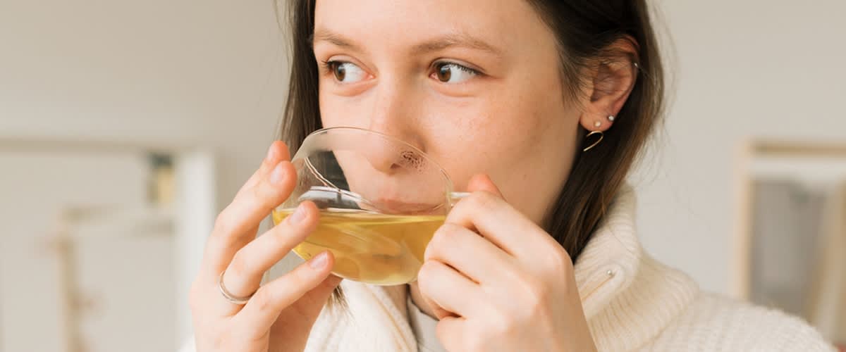 Frau trinkt Tee aus Glastasse