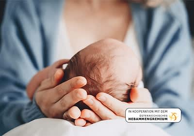 Mutter haelt Kopf von Baby in beiden Haenden