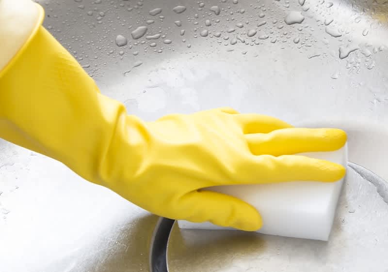 Abfluss reinigen mit gelbem Gummihandschuh