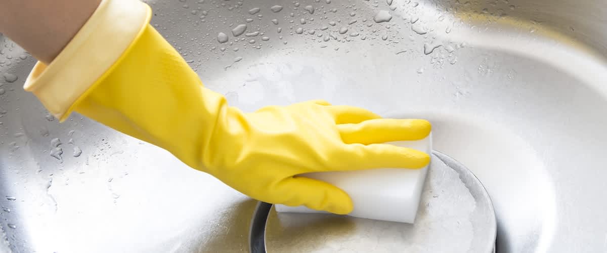 Abfluss reinigen mit gelbem Gummihandschuh