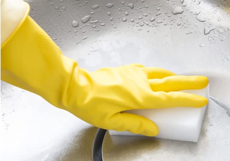 Abfluss reinigen mit gelbem Gummihandschuh