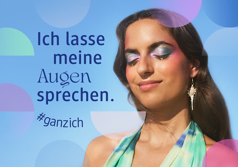 Frau mit langen Haaren, türkis-grünem Neckholderkleid und auffälligem Ohrring vor blauem Hintergrund mit dem Text „Ich lasse meine Augen sprechen. #ganzich“