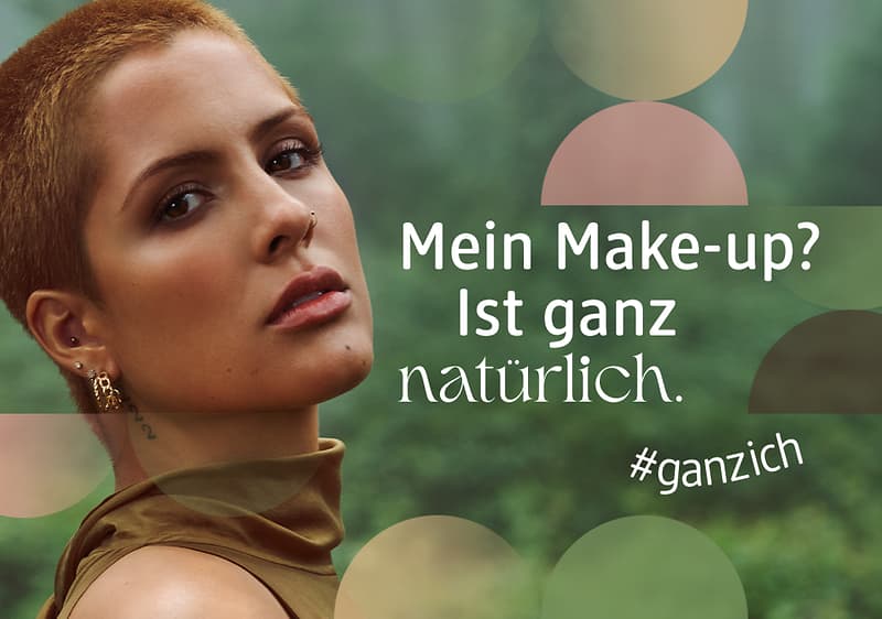 Porträt einer Person mit kurzem Haar, daneben weißer Schrift: „Mein Make-up? Ist ganz natürlich.“ und Hashtag „#ganzich“