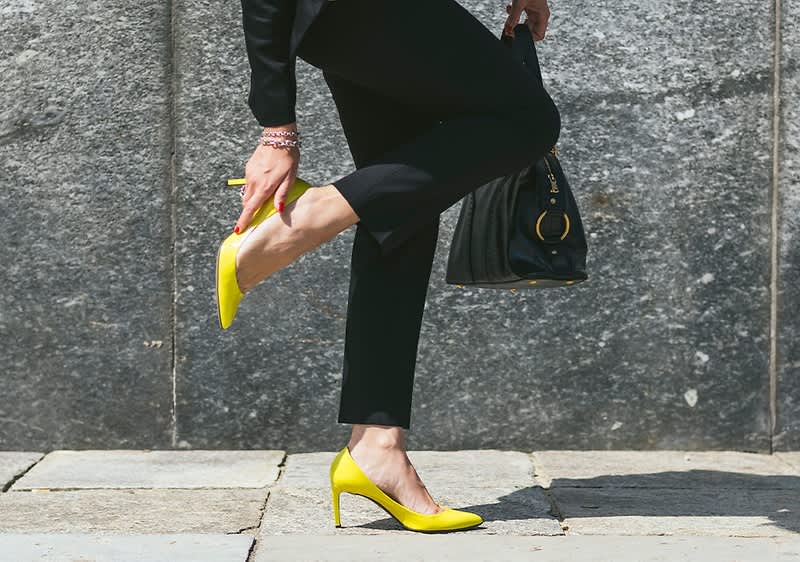 Blasen am Fuß in gelben Stoeckelschuhen