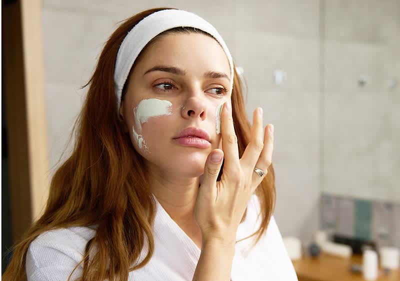 Frau beim Gesicht eincremen