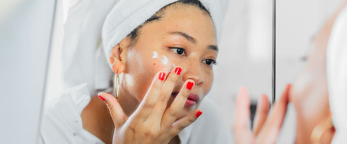 Frau beim Gesicht eincremen